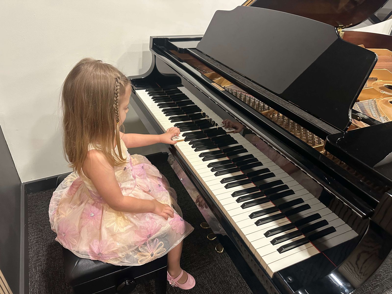 Young student playing a grand piano
