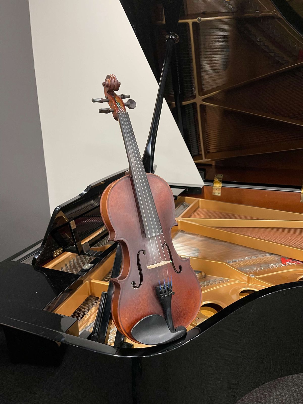 Violin resting inside an open grand piano